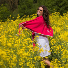 Lade das Bild in den Galerie-Viewer, Madchen mit braunen langen Haaren dreht sich im Rapsfeld und trägt ein hellrotes Merinowolltuch mit grauer Einfassung